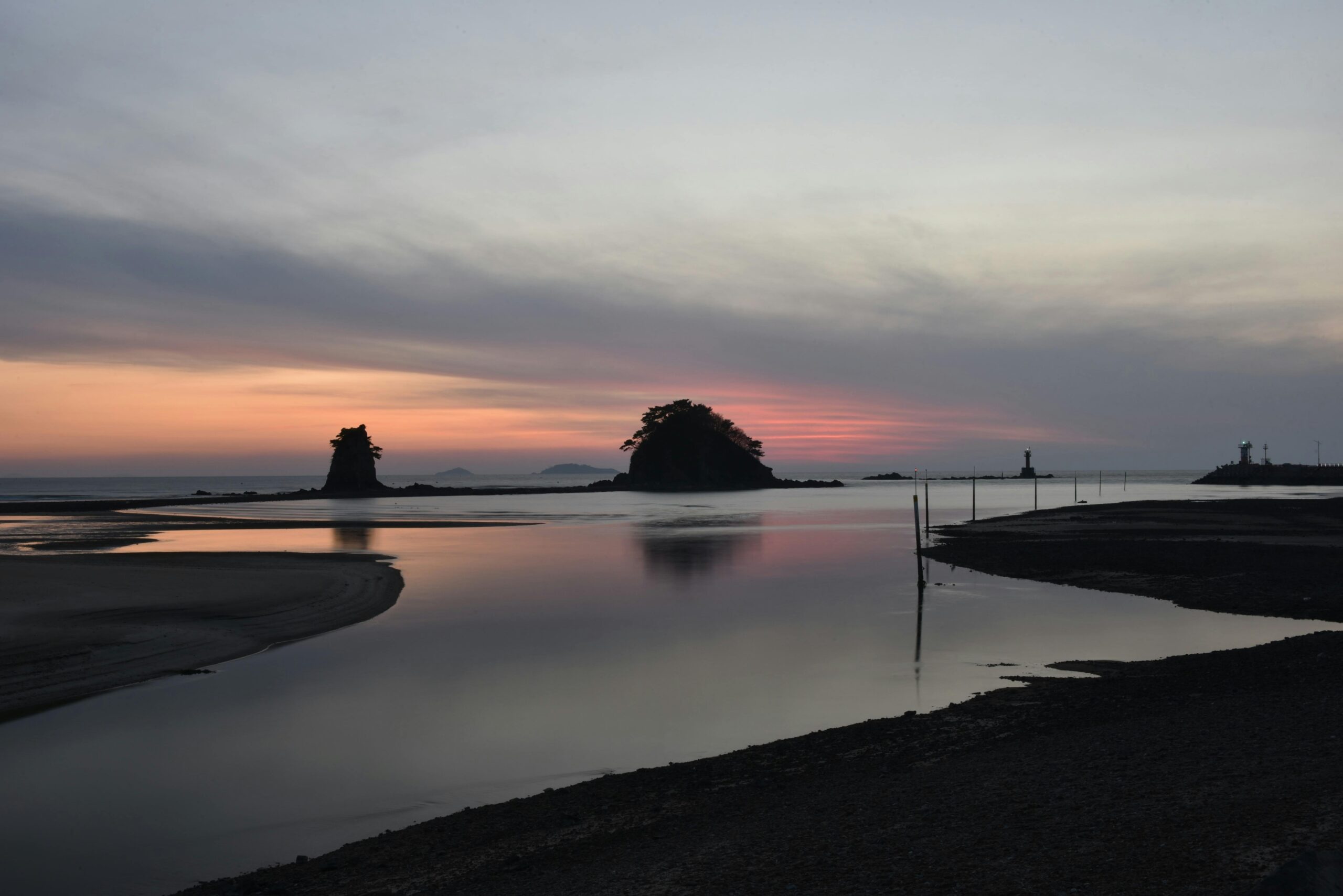 A peaceful sunset at Taean's coastline with calm waters and a dramatic sky.